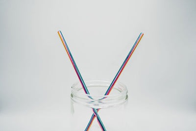two stainless steel reusable straws straight rainbow in a jar
